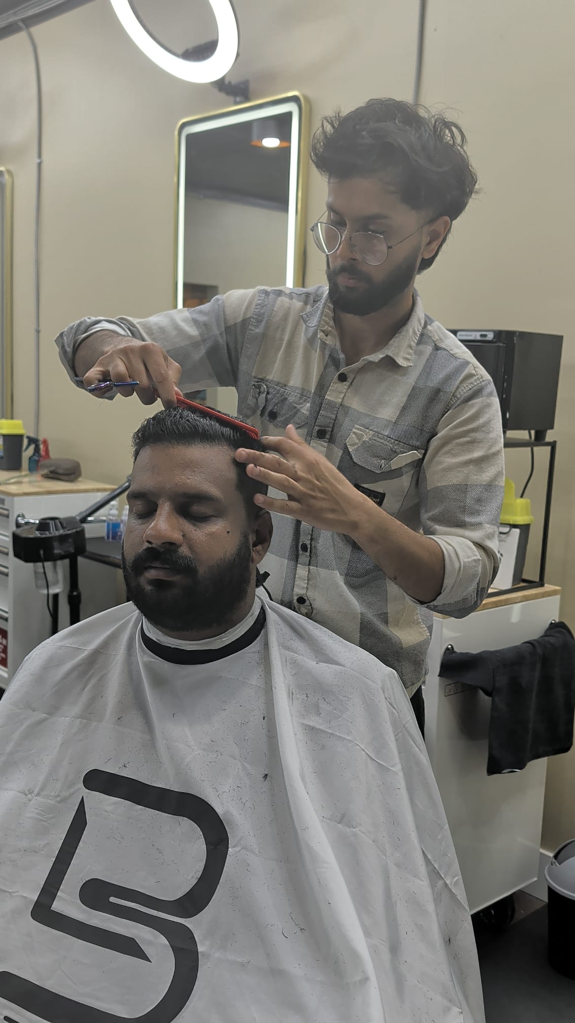 A barber combing a client's hair into place