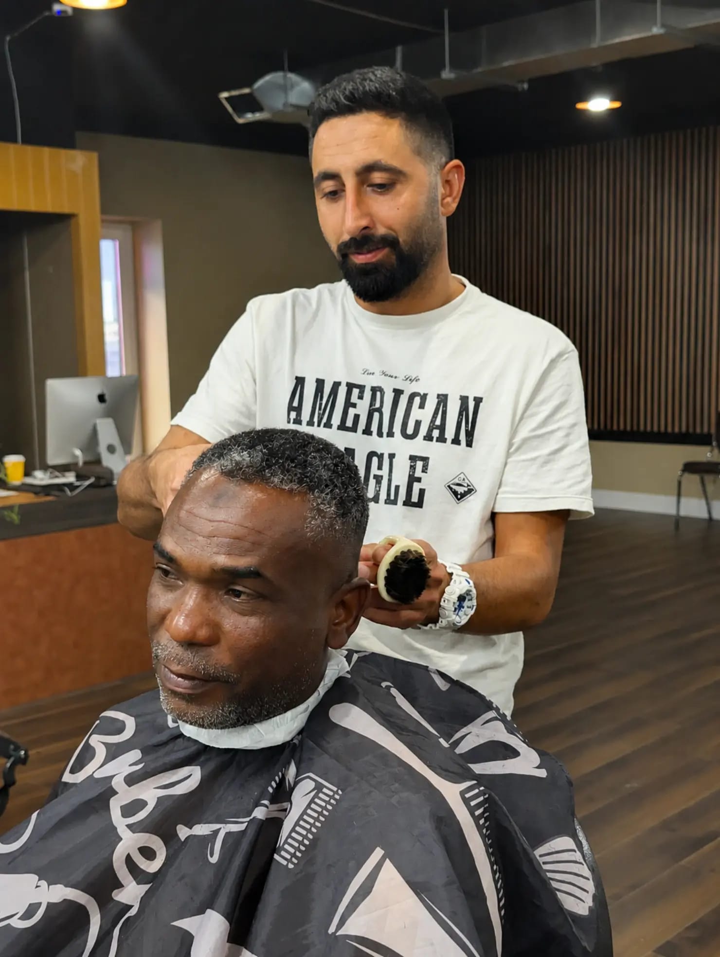 A barber finishing a cut with talc powder